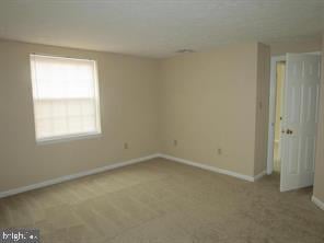 unfurnished room featuring baseboards