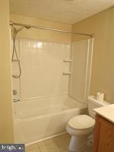 bathroom featuring shower / bathing tub combination, tile patterned flooring, vanity, and toilet