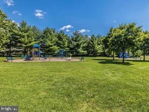 view of home's community with a lawn and playground community