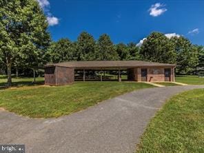 surrounding community featuring aphalt driveway and a lawn