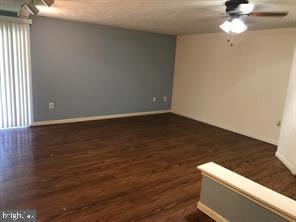 spare room featuring ceiling fan and dark wood-style flooring