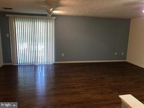 empty room with baseboards and wood finished floors