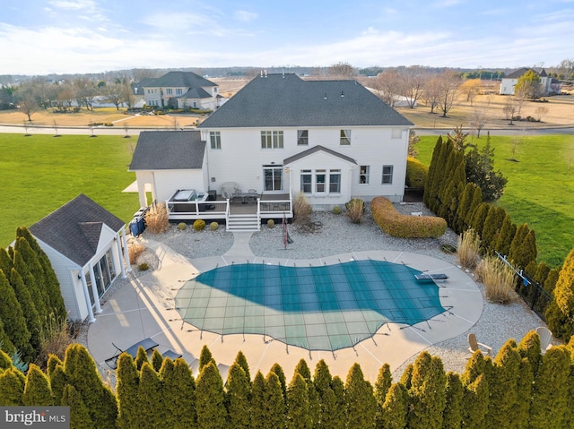 rear view of property with a patio, fence private yard, a yard, a wooden deck, and a fenced in pool