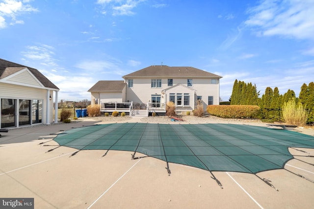 view of swimming pool with a covered pool, a patio, and a wooden deck