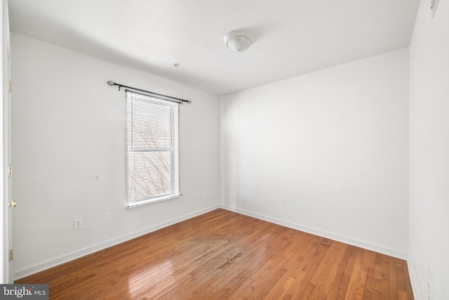 empty room featuring baseboards and wood finished floors