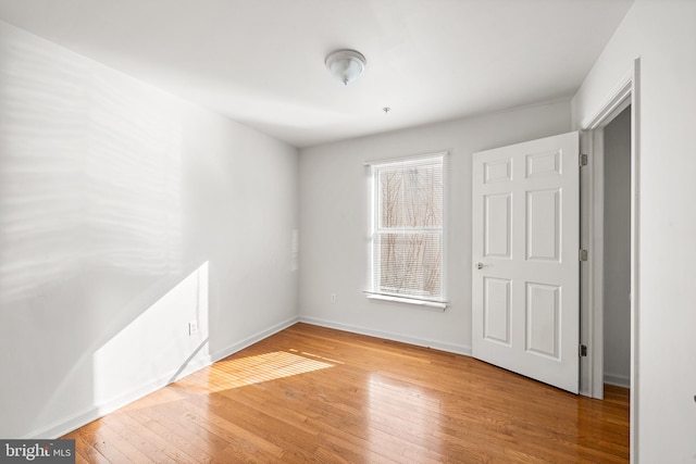 unfurnished bedroom featuring wood finished floors and baseboards