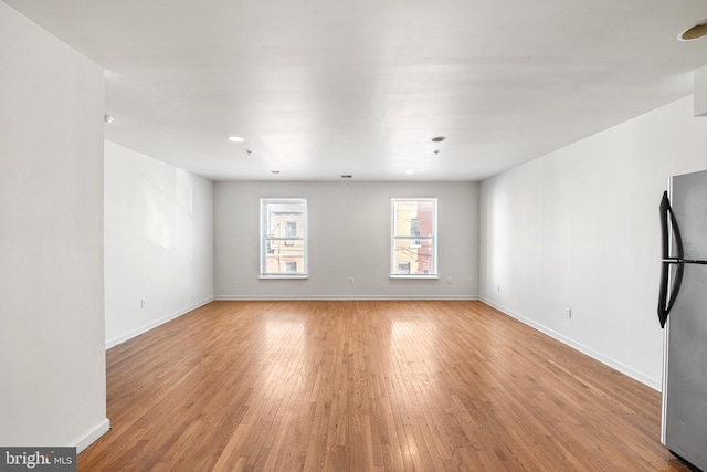 spare room with light wood-type flooring and baseboards