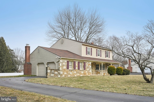 view of front facade featuring a chimney, an attached garage, fence, stone siding, and a front lawn