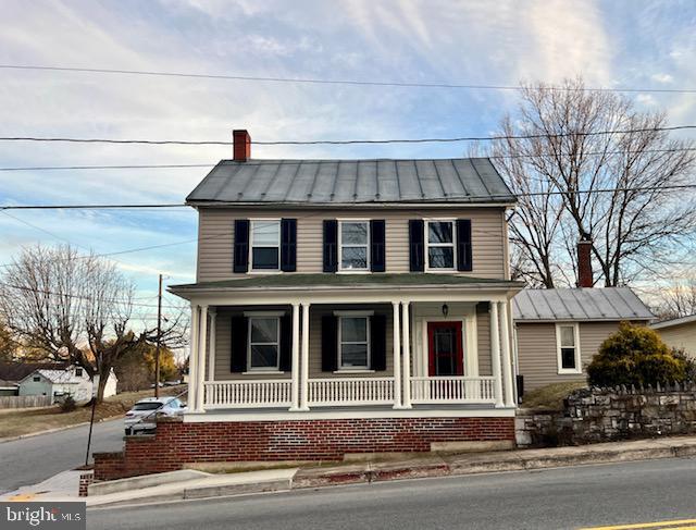 view of front of home with covered porch, metal roof, and a standing seam roof