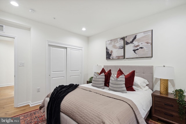 bedroom with recessed lighting, a closet, baseboards, and wood finished floors