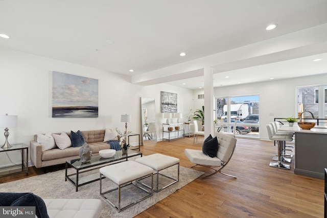 living area with light wood finished floors and recessed lighting