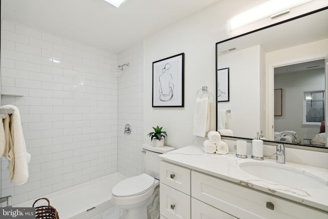 full bathroom featuring visible vents, a tile shower, vanity, and toilet