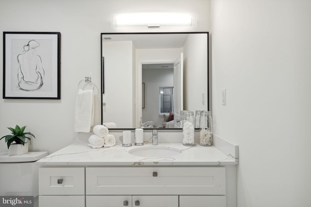 bathroom featuring toilet, connected bathroom, and vanity