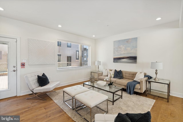 living area with light wood-style floors, baseboards, and recessed lighting