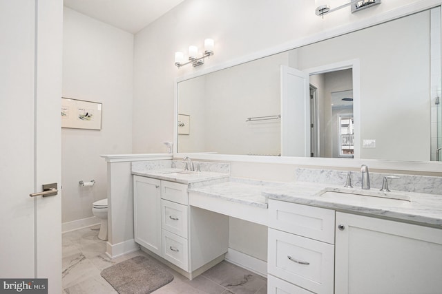 bathroom with marble finish floor, a sink, and double vanity