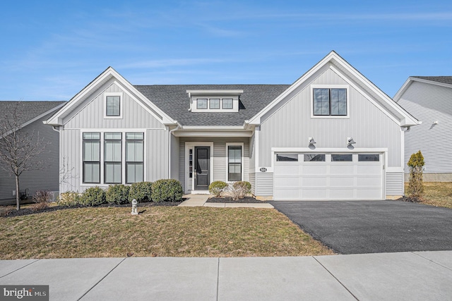 view of front of property with roof with shingles, an attached garage, board and batten siding, driveway, and a front lawn