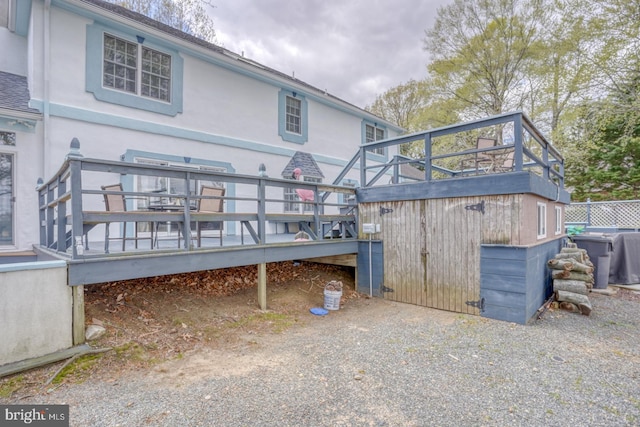 rear view of property with stucco siding and a deck