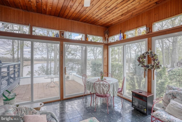 sunroom with wooden walls, a water view, and wooden ceiling
