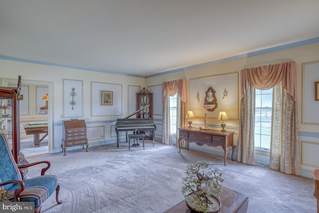 living area featuring carpet, a decorative wall, and crown molding
