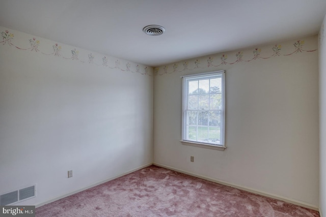 spare room featuring visible vents, baseboards, and light carpet