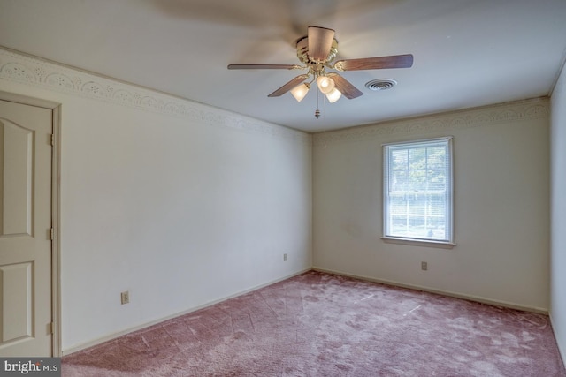 carpeted empty room with ceiling fan, baseboards, and visible vents