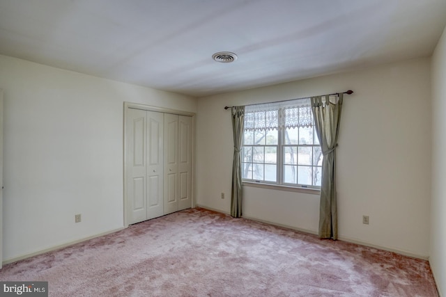 unfurnished bedroom with a closet, visible vents, and carpet flooring