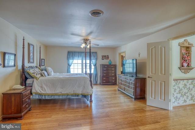 bedroom with baseboards, a ceiling fan, light wood-style floors, and visible vents