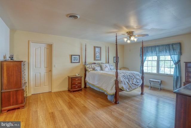 bedroom with light wood-style flooring, visible vents, a ceiling fan, and baseboards