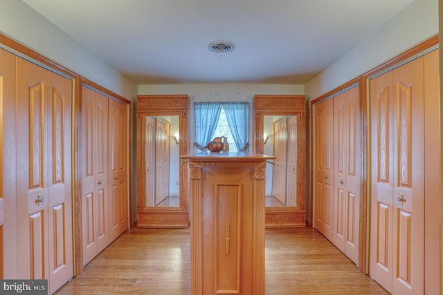 hallway featuring visible vents and light wood finished floors