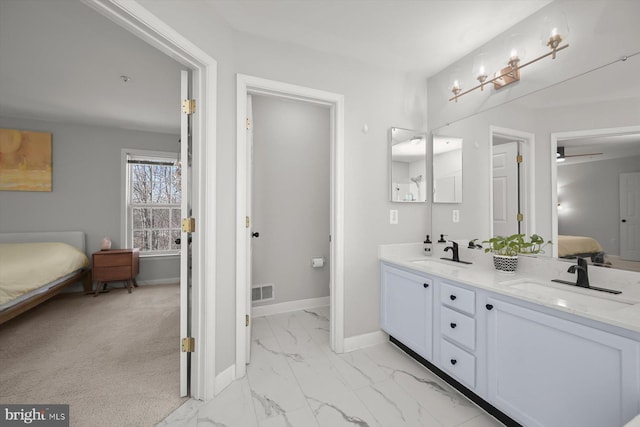 ensuite bathroom with ensuite bathroom, marble finish floor, a sink, and baseboards