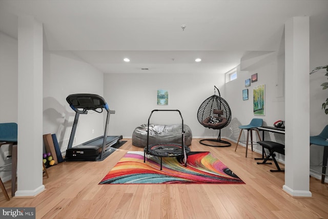 workout area featuring baseboards, wood finished floors, and recessed lighting