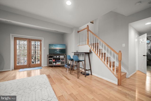 foyer entrance with recessed lighting, baseboards, light wood finished floors, and stairs