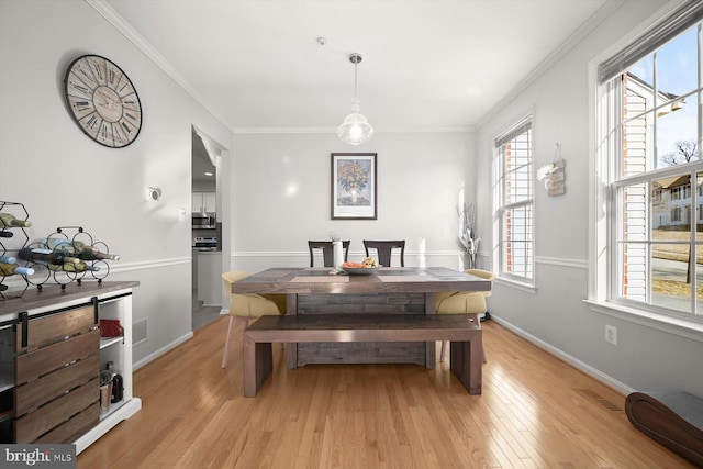 dining area with visible vents, crown molding, light wood-style flooring, and baseboards