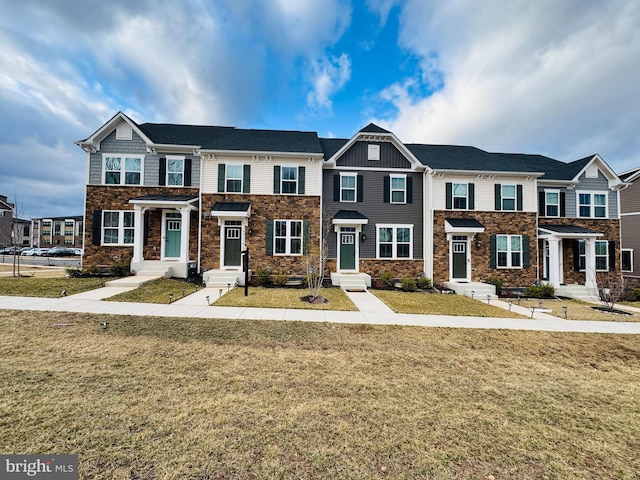 multi unit property featuring stone siding and a front lawn