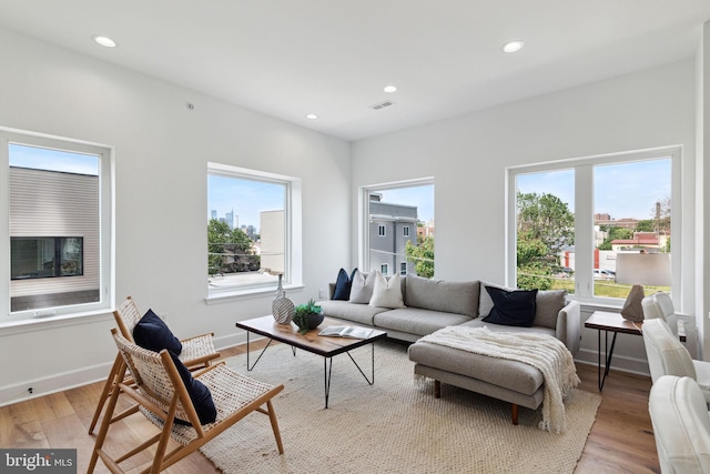 living room featuring light wood-style floors, visible vents, and recessed lighting