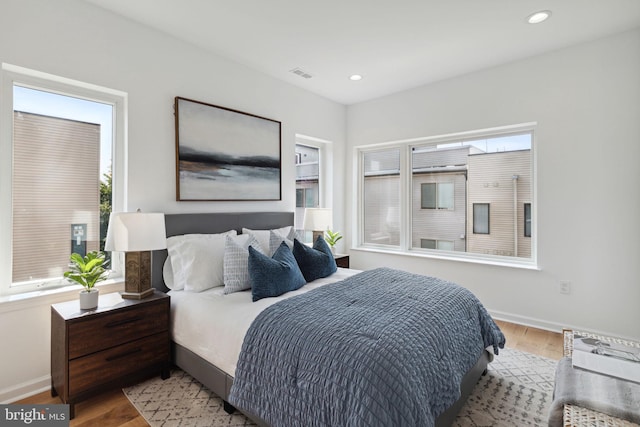 bedroom featuring baseboards, light wood-type flooring, visible vents, and recessed lighting