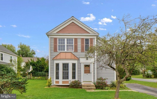 view of front of property with a standing seam roof, driveway, a front lawn, and metal roof