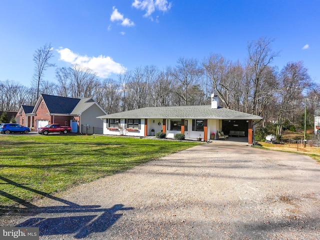 single story home featuring an attached carport, a porch, a front yard, a chimney, and driveway