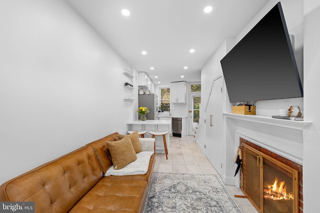 living area with light tile patterned floors, a fireplace with flush hearth, and recessed lighting