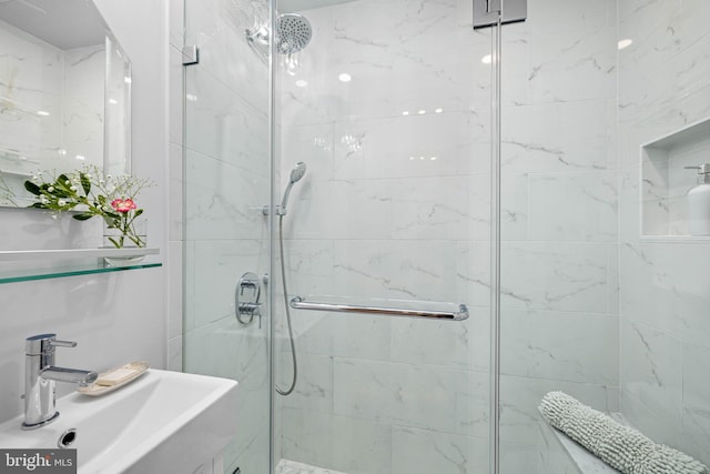 full bathroom featuring a stall shower and a sink