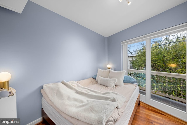 bedroom with lofted ceiling and wood finished floors