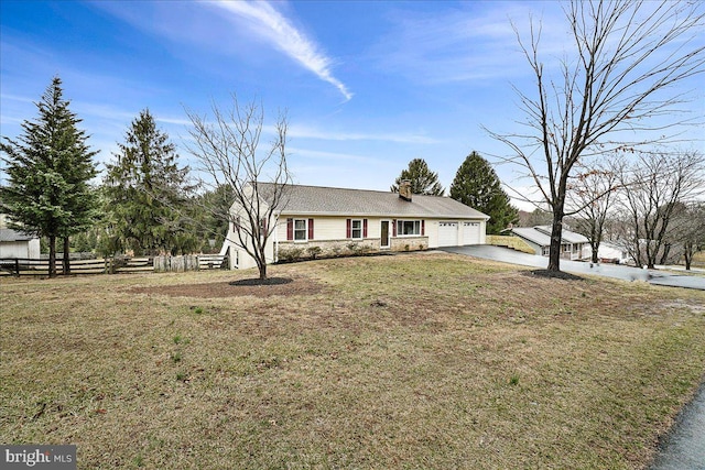 ranch-style house featuring aphalt driveway, an attached garage, fence, a chimney, and a front yard