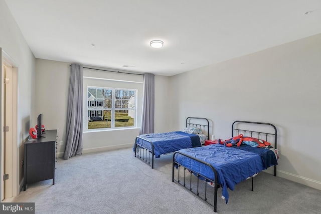 bedroom featuring light carpet and baseboards