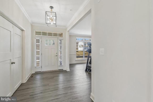 foyer with baseboards, ornamental molding, a chandelier, and dark wood-type flooring