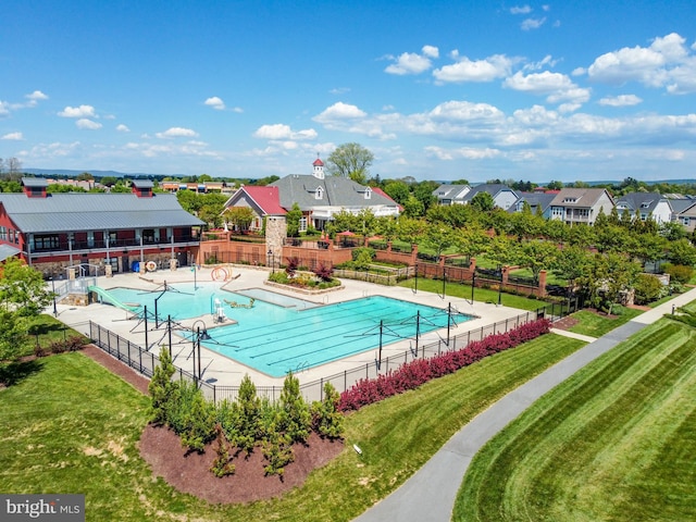 pool featuring a residential view, a patio area, a yard, and fence