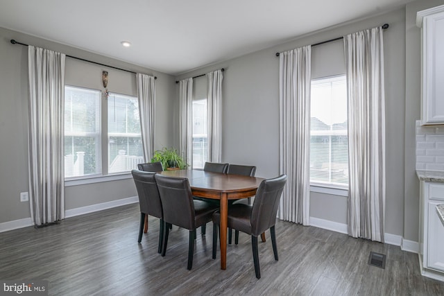 dining area with wood finished floors, visible vents, and baseboards