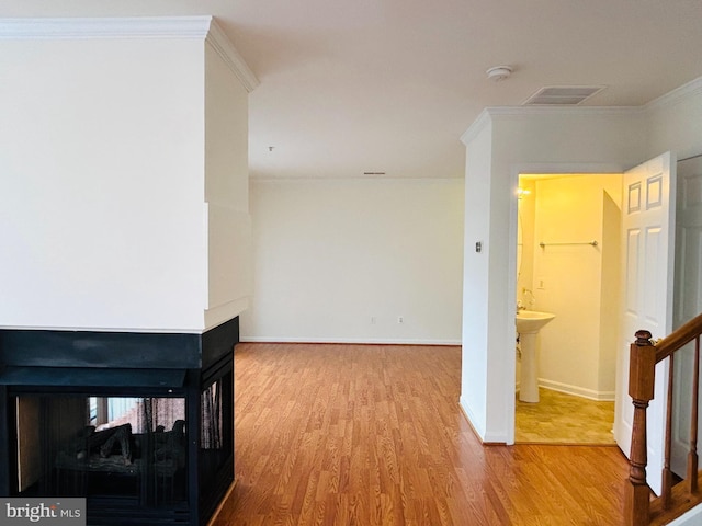 interior space featuring stairs, baseboards, wood finished floors, and crown molding