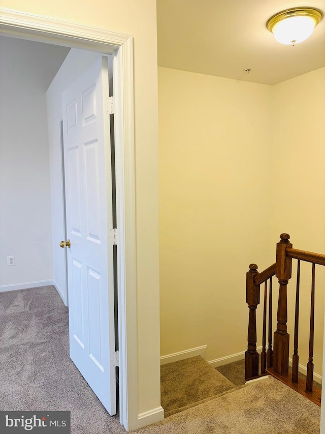 staircase featuring carpet floors and baseboards