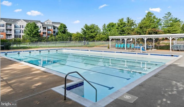 community pool with a patio area, fence, and a pergola