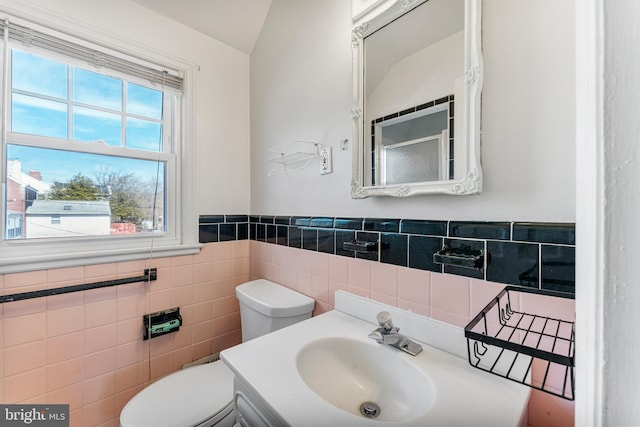 bathroom with a wainscoted wall, tile walls, toilet, and vanity